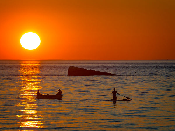 Two Men On A Boat And Man On Paddleboard